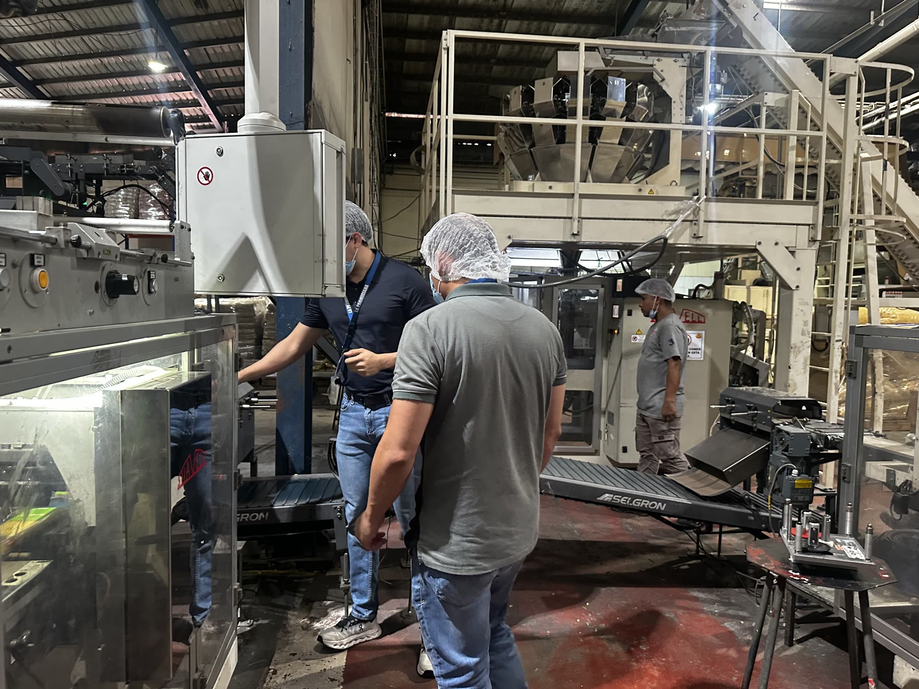 Técnicos de BVCP integrando un transportador de salida con la empacadora en planta de pastas
