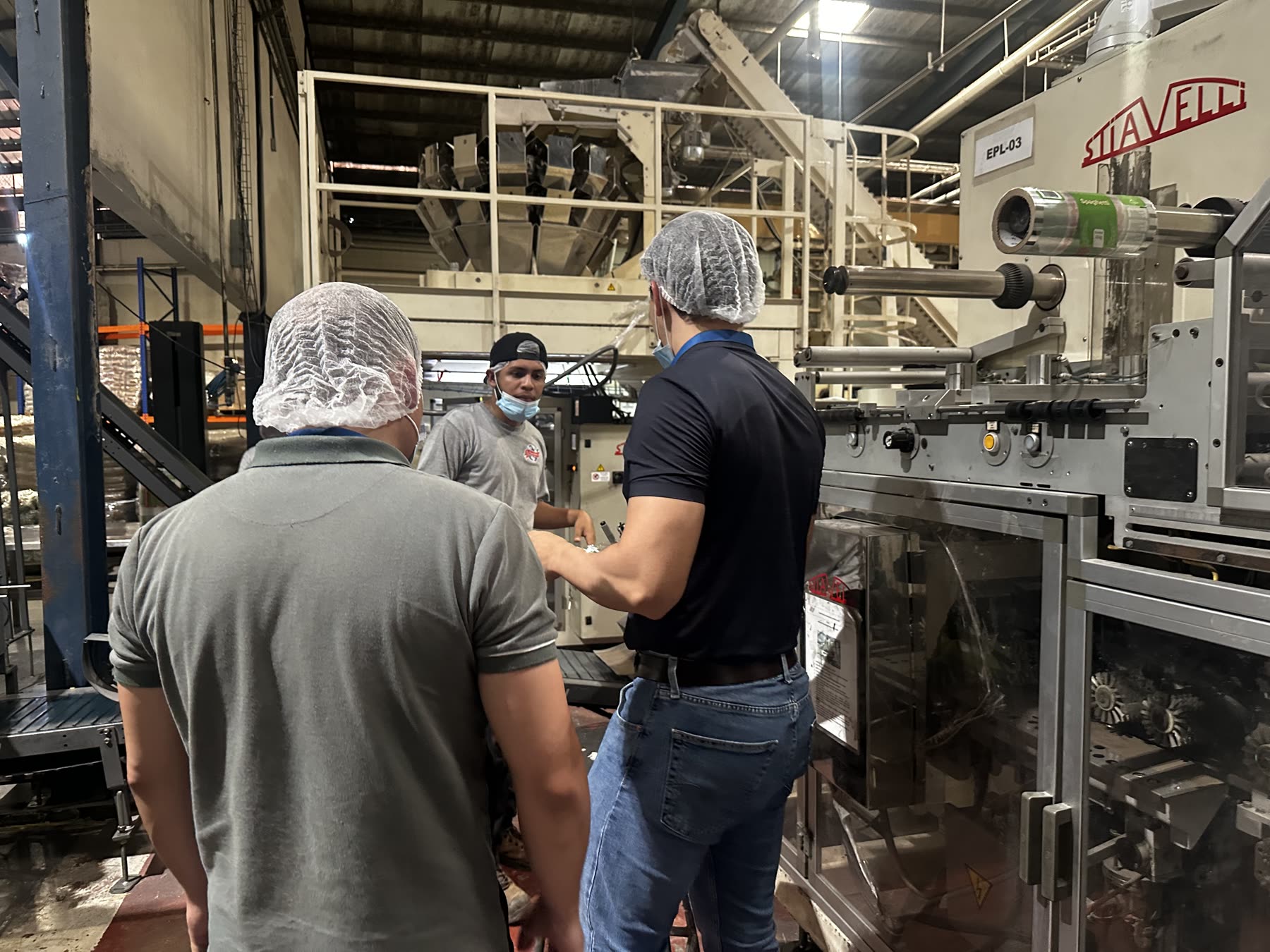Equipo técnico de BVCP revisando una empacadora vertical con pesadora multicabezal en planta de alimentos